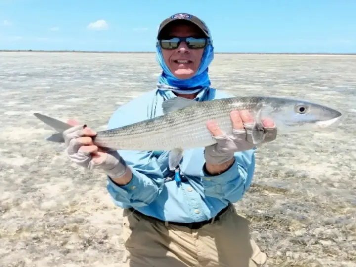 Angler holding a bonefish on the Grand Bahama flats